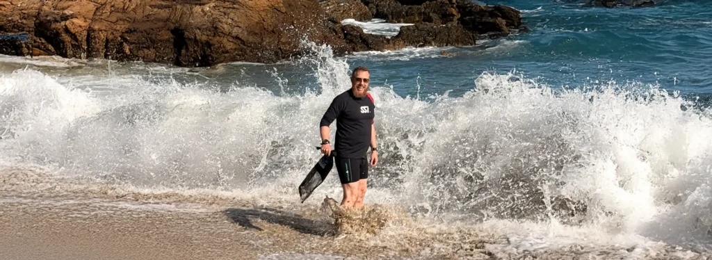 Phil Anderegg, SSI Scuba Diving Instructor collecting trash on a beach in Menorca, Spain